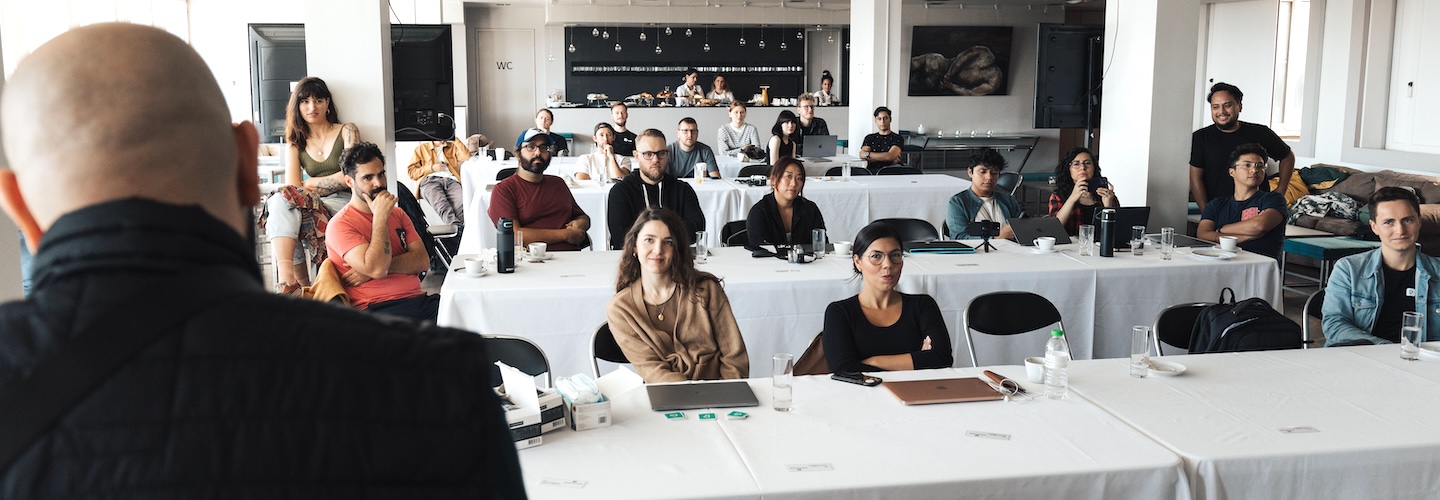Employees sitting in a meeting looking annoyed